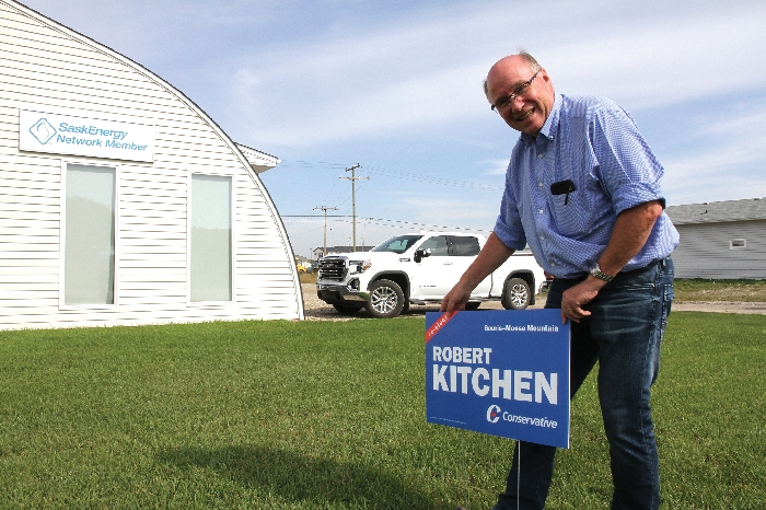 Robert Kitchen puts up a Conservative lawn sign in Moosomin
